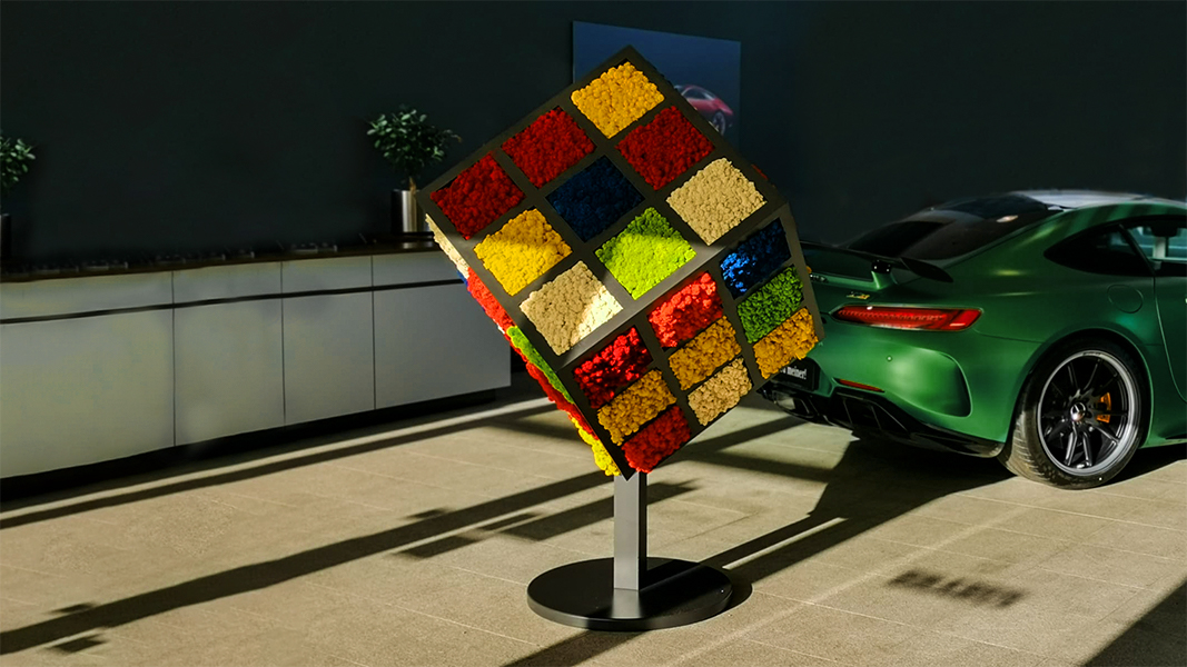 Ein Zauberwürfel aus verschiedenfarbigem Islandmos steht als Dekoelement auf einer Automesse