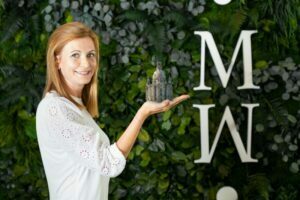 Nicole-Gommlich MoosMoos Vertriebsmitarbeiterin Nicole Gommlich aus Dresden hält eine Miniatur der Frauenkirche vor einer Dschungelmooswand