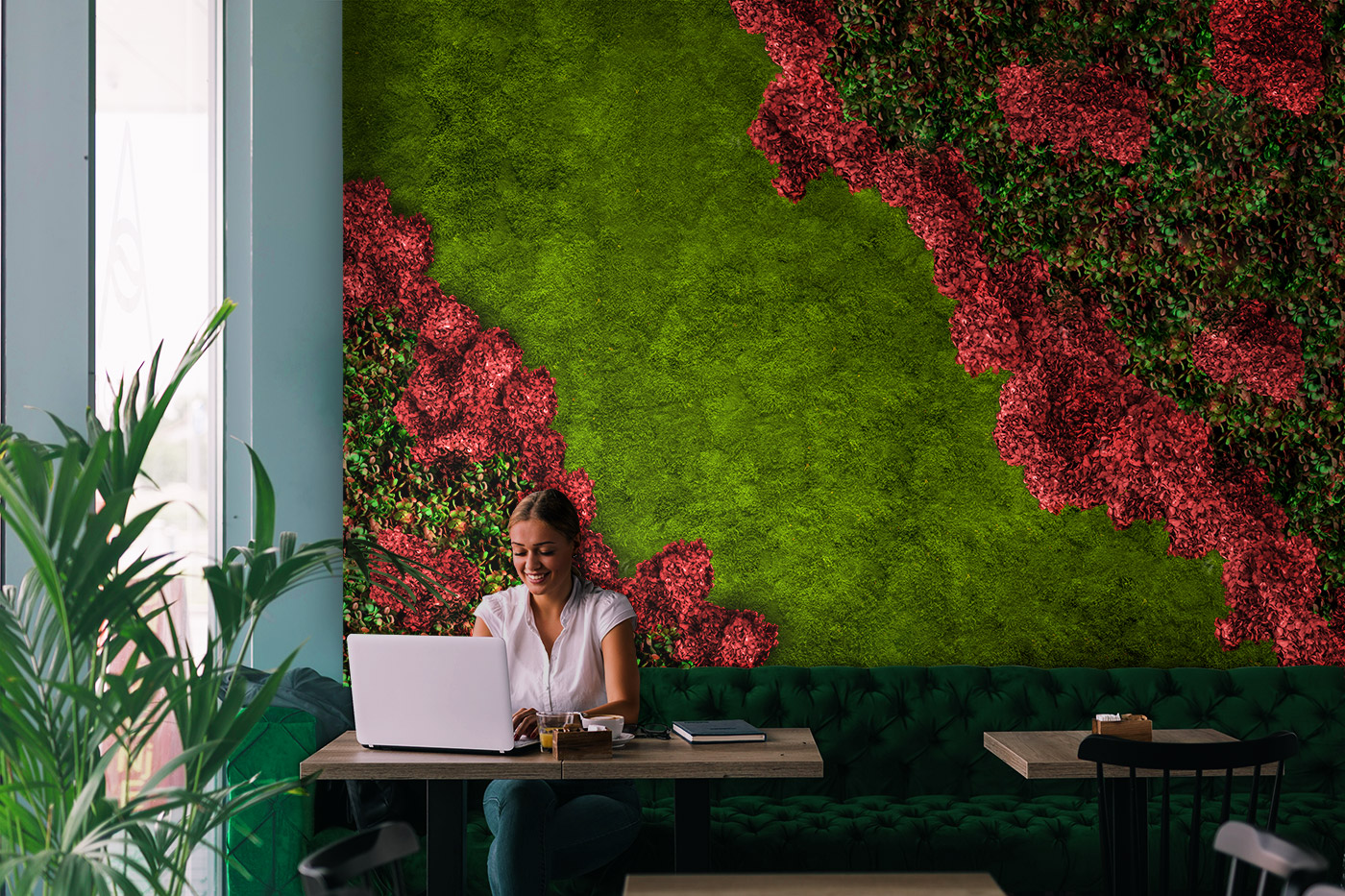 Mooswand mit Hortensien und Pflanzen in einem Caffee und im Vordergrund sitzt eine Frau